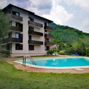 a building with a swimming pool in front of a building at Appartamento Levico lake in Levico Terme