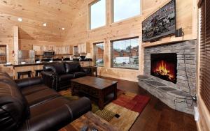 a living room with leather furniture and a fireplace at Breathtaking Cabin with Hot-tub, Fireplace and Games in Sevierville, Tennessee in Little Cove
