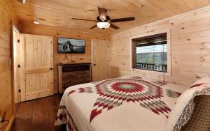 a bedroom with a bed and a ceiling fan at Breathtaking Cabin with Hot-tub, Fireplace and Games in Sevierville, Tennessee in Little Cove