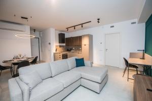 a living room with a white couch and a kitchen at Compagnoni Suite Luxe - Spa & Wellness in Milan