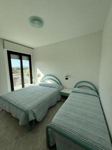 two beds in a room with a window at Residenza Paradiso in Bellaria-Igea Marina