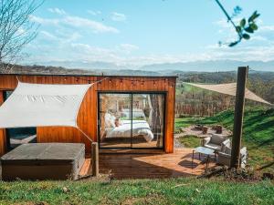 LasseubeChalet insolite - SPA - Vue Pyrénées - Brasero的小型帐篷,配有一张床和一张椅子,位于甲板上