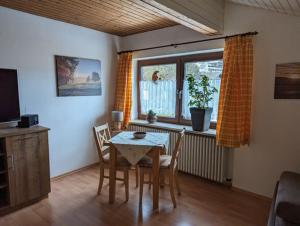 a dining room with a table and chairs and a window at Ferienwohnung Dallinger in Anger