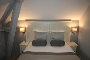 a bedroom with a bed with two pillows on it at Les Embruns in Trouville-sur-Mer