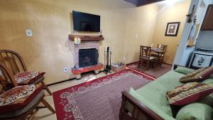 a living room with a fireplace with a tv above it at Chalé Recanto Boreal in Monte Verde +22 photos