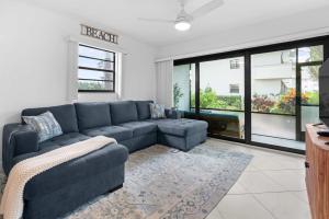 a living room with a blue couch and a large window at Stunning Condo at Park Shore Resort 149 in Naples