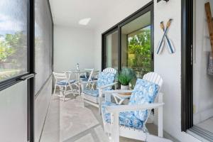 a porch with white chairs and a table and a window at Stunning Condo at Park Shore Resort 149 in Naples