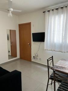 a living room with a table and a window at Apto Aconchegante Catanduva V in Catanduva