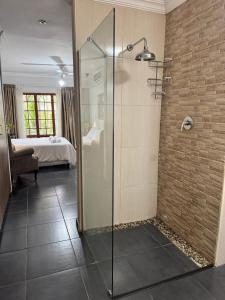 a glass shower in a bathroom with a bedroom at Ben & Bern House in Krugersdorp +22 photos