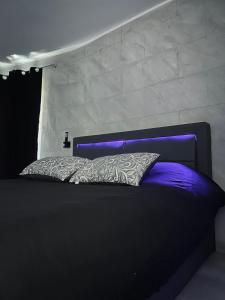 a black bed with a blue headboard and a pillow at Il Rifugio Nel Vicolo in Subiaco
