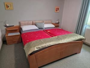 a bedroom with a large bed with a red blanket at Komfort-Ferienwohnung Südbalkon, WOHNZIMMER, 2 Schlafzimmer, ruhige Lage - TIROL in Reutte