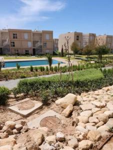 塔哈佐特Taghazout Paradise - Duplex Confort - Vue mer piscine - Agadir的一座建筑前有岩石的花园