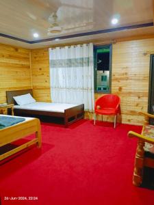 a bedroom with a bed and a red carpet at The Tourists Inn in Chak
