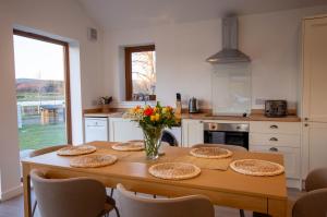 a kitchen with a wooden table with a vase of flowers at Heathfield Highland Estate in Invergordon