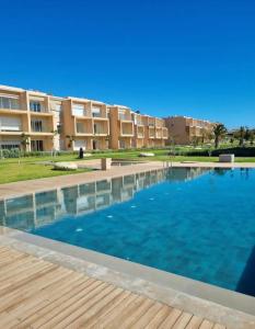 塔哈佐特Taghazout Paradise - Duplex Confort - Vue mer piscine - Agadir的建筑物前的一个大型游泳池