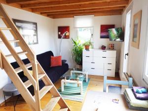 een woonkamer met een blauwe bank en een trap bij "Les Echalas" Chalet indépendant avec cuisine en Lavaux Unesco in Chexbres