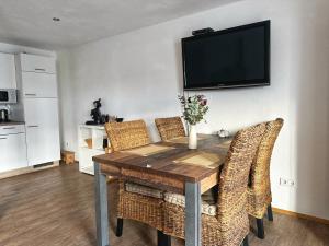 mesa de comedor con sillas y TV en la pared en Landhof Riehlingshöhe, en Kisslegg 6 fotos más