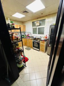 a kitchen with a stove and a counter with a shelf at Single private room with shared washroom and kitchen in Sharjah
