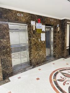 a lobby with two elevators in a building at Single private room with shared washroom and kitchen in Sharjah