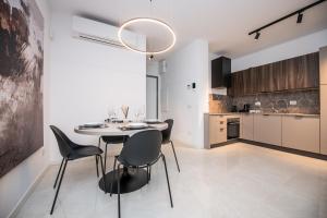 a kitchen and dining room with a table and chairs at Compagnoni Suite Luxe - Spa & Wellness in Milan +27 photos