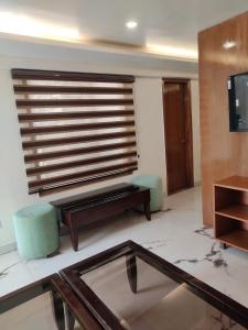 a living room with a bench and a tv at Royal Park - Hotels & Resorts in Ghaziabad