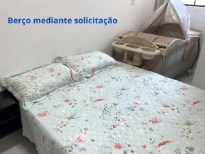 a bedroom with a bed with a floral comforter at Varanda Gourmet Diversão Pet Praia do Francês in Praia do Frances +24 photos