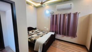 a bedroom with a bed with a purple shower curtain at PENTHOUSE -Thanjavur home stays in Thanjāvūr