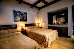 a bedroom with two beds and a mirror at Nanshe MuXi Heritage Inn in Zhangjiajie