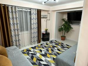 a living room with a checkered floor at Уютный уголок кв 54 in Shymkent