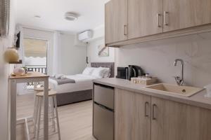 une cuisine avec un évier et une chambre avec un lit dans l'établissement Plaka Studios 2, à Benitses