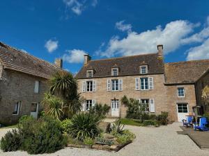 Gatteville-le-PhareLA FERME DE NEHOU的一座大砖砌建筑,庭院内种有棕榈树