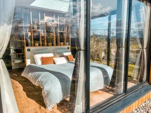 LasseubeChalet insolite - SPA - Vue Pyrénées - Brasero的一间带玻璃窗和床的卧室