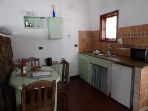 a small kitchen with a table and a sink at Casa Rural "La Molina" in Máguez