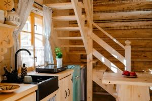 a kitchen with wooden walls and a wooden staircase at Sopki Stopki Polana Wspólna in Cięcina +10 photos
