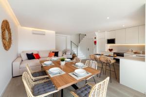 a kitchen and living room with a wooden table and chairs at Townhouse Crystal Bay by Algarve Vacation in Benagil