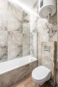 La salle de bains est pourvue de toilettes blanches et d'une baignoire. dans l'établissement Stylish property, Self check in 24h, Netflix, parking, à Vilnius