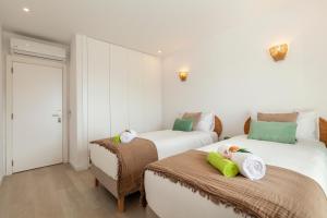 a bedroom with two beds with towels on them at Townhouse Crystal Bay by Algarve Vacation in Benagil