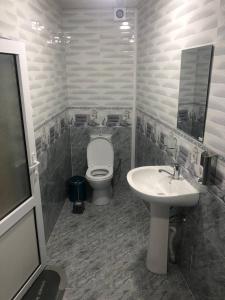 un baño con inodoro y lavabo en Nur Xostel, en Samarkand