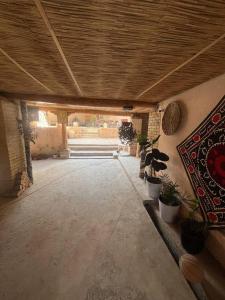Habitación con macetas y techo de madera. en Nur Xostel, en Samarkand