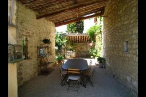 un patio avec une table et des chaises dans un bâtiment dans l'établissement Gîte une treille en provence, à Saint-Didier
