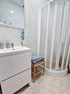 Un baño con un lavabo y una silla junto a una ducha. en Bright Apartment in Seville with Private Garden, en Sevilla 29 fotos más