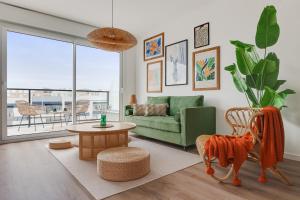 a living room with a green couch and a table at way2sun penthouses - FREE e-bikes & jacuzzi & solarium & PS5 in Gran Alacant