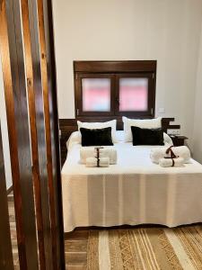 une chambre avec un grand lit avec des draps et des oreillers blancs dans l'établissement Los Nidos de Nines, à Cabezabellosa