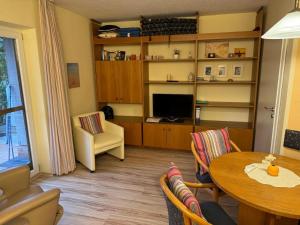 a living room with a table and a television at Weinmanns Wildgatter in Grafenwiesen