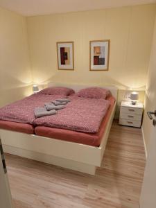 a bedroom with a bed with red comforter at Weinmanns Wildgatter in Grafenwiesen