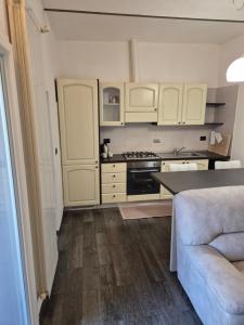a kitchen with white cabinets and a couch at 20 Minutes to FLORENCE in Prato
