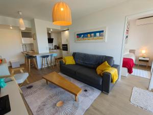 a living room with a couch and a table at Appartement toit terrasse Nice-ouest avec parking, clim et piscine in Nice