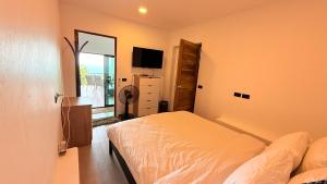 a bedroom with a bed and a television in it at Koh Tao Studios Family Suite in Ko Tao