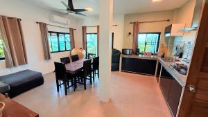 a kitchen and a living room with a table and chairs at Koh Tao Studios Family Suite in Ko Tao