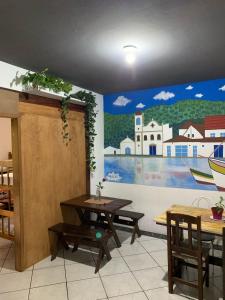 a room with a table and a painting on the wall at Embaúba Paraty - Hostel & Flats in Paraty +30 photos